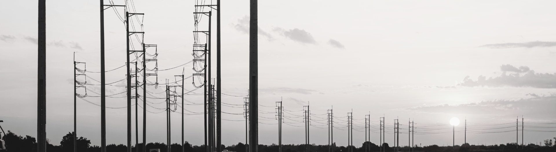 Power Line Perspective Silhouette of power lines against a setting sun, showcasing the grid's reach and infrastructure.